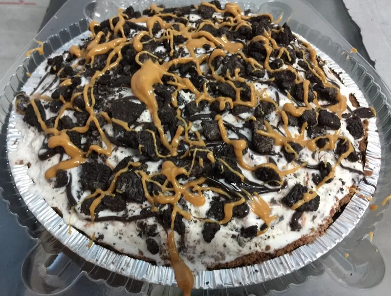 Peanut butter cup ice cream pie topped with Oreo crumbles and caramel drizzle